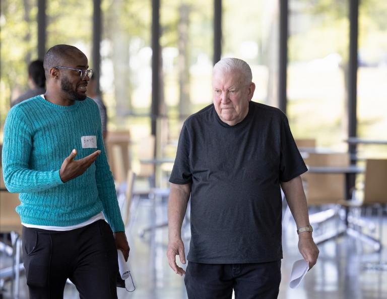 Photo of student and senior man walking and talking